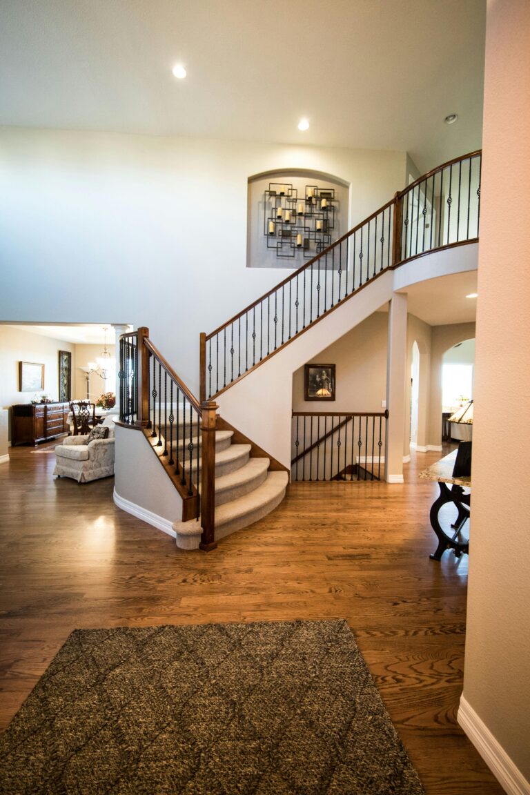 Spacious modern interior showcasing a stylish wooden staircase and elegant decor.