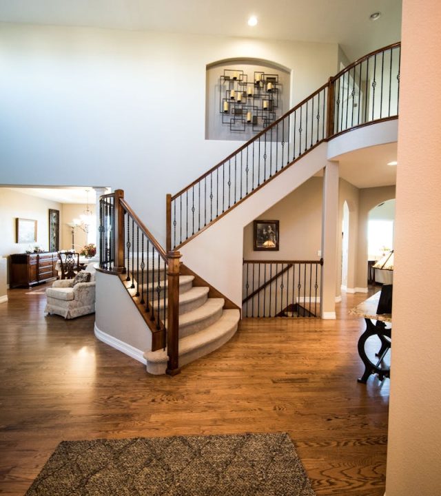 Spacious modern interior showcasing a stylish wooden staircase and elegant decor.